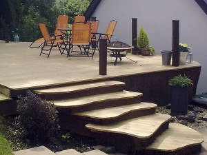 Curved timber decking with organic shaped steps leading to seating area. Designed and built by Evergreen Wales