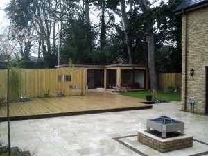 Modern landscape designed to include a new outside office, fresh turf, patio and stonework with a large decking surround. Designed and built by Evergreen Wales.