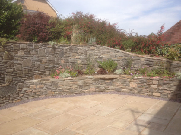 Raised stone wall with tiered flower beds