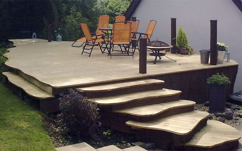 Organic curved styled outdoor steps curved up towards a timber seating area. Design and build by Evergreen Wales.